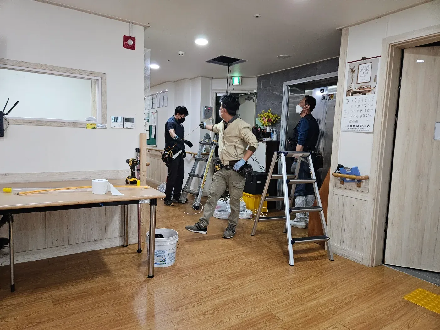 설치 현장에서 기사들과 시설 직원이 함께 이야기하는 모습