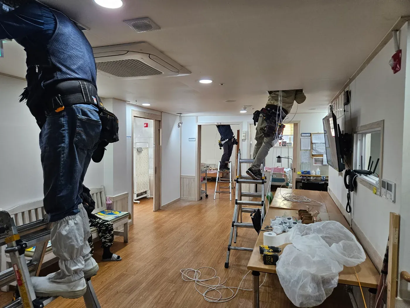 기사님들이 사다리에 올라 실내 천장에 CCTV를 설치하는 모습